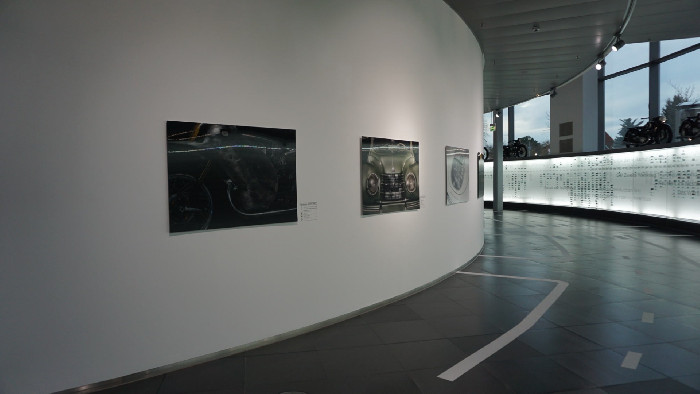 Lentikularbilder an der geschwungenen Ausstellungswand im Audi-Museum