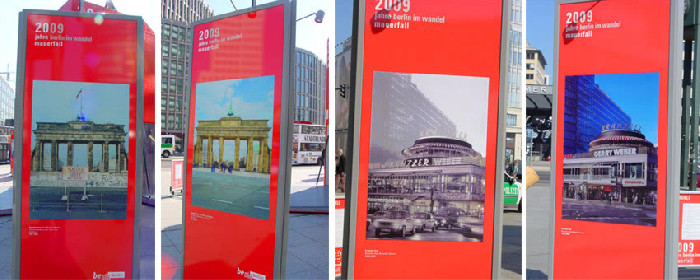 Red exhibition columns showing historical and more recent views of Berlin